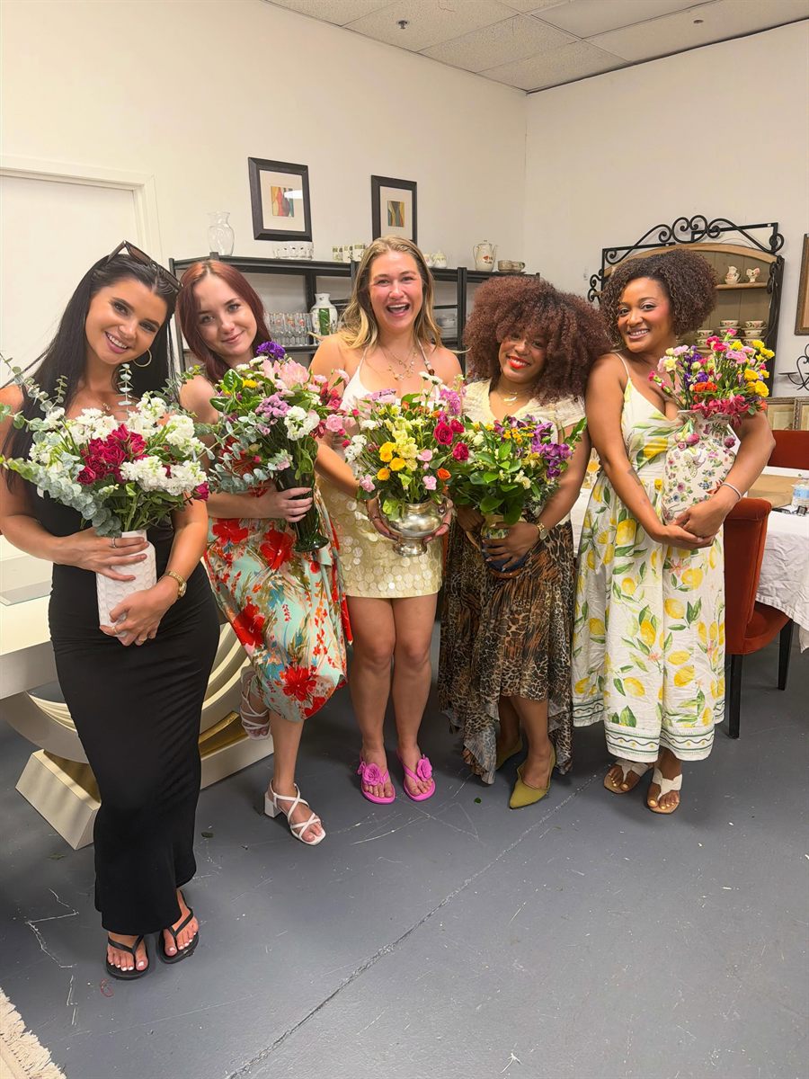 Five NYC Content Creator Girlies members smiling and holding the flower bouquets they arranged at a community workshop
